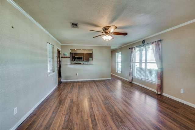 unfurnished living room featuring ceiling fan, dark hardwood / wood-style flooring, a textured ceiling, and ornamental molding