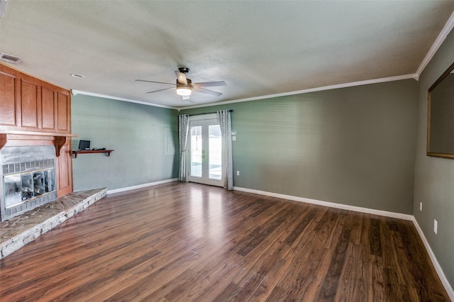 unfurnished living room featuring dark hardwood / wood-style flooring, ceiling fan, a stone fireplace, and crown molding