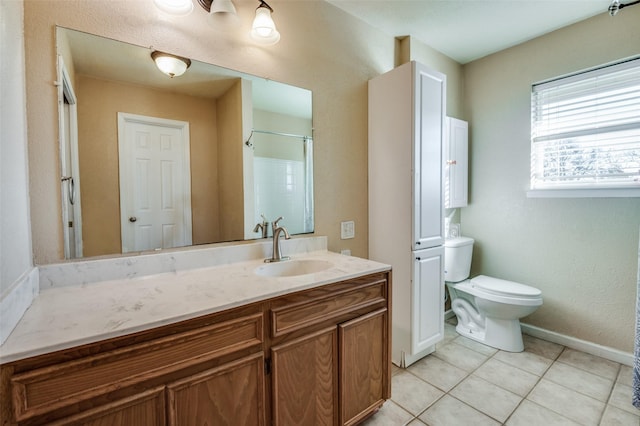 bathroom with tile patterned flooring, vanity, toilet, and walk in shower