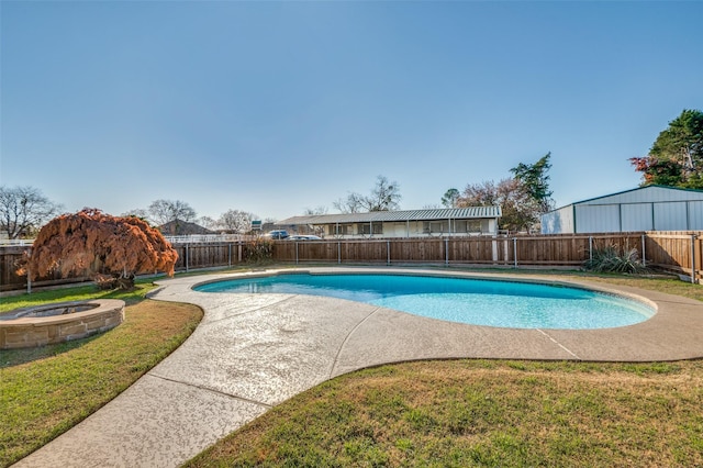 view of swimming pool with a lawn and a jacuzzi