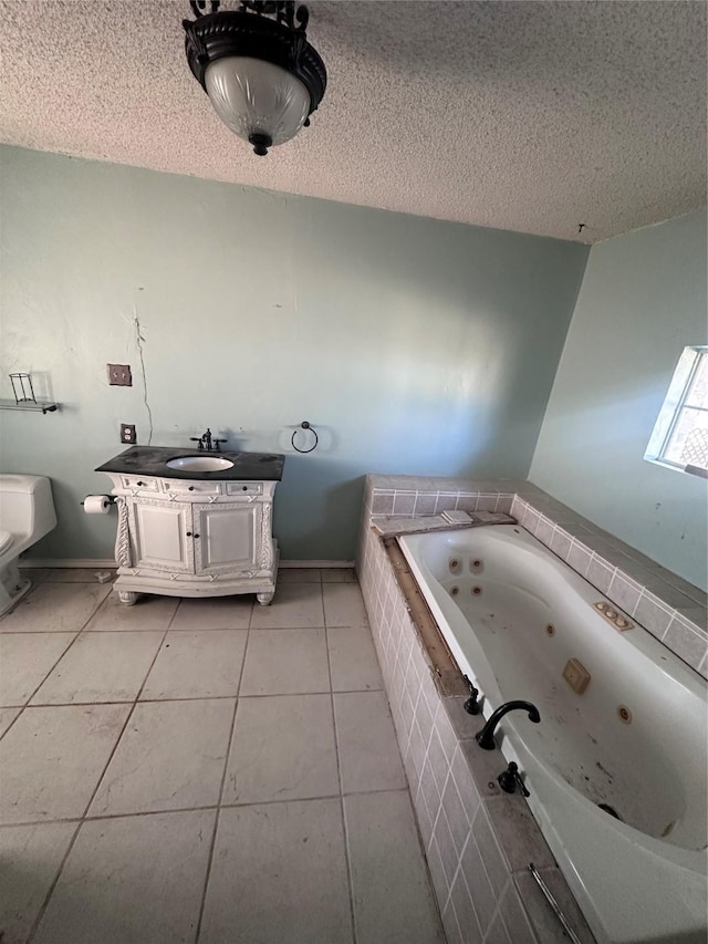 bathroom with tile patterned flooring, vanity, a textured ceiling, and toilet