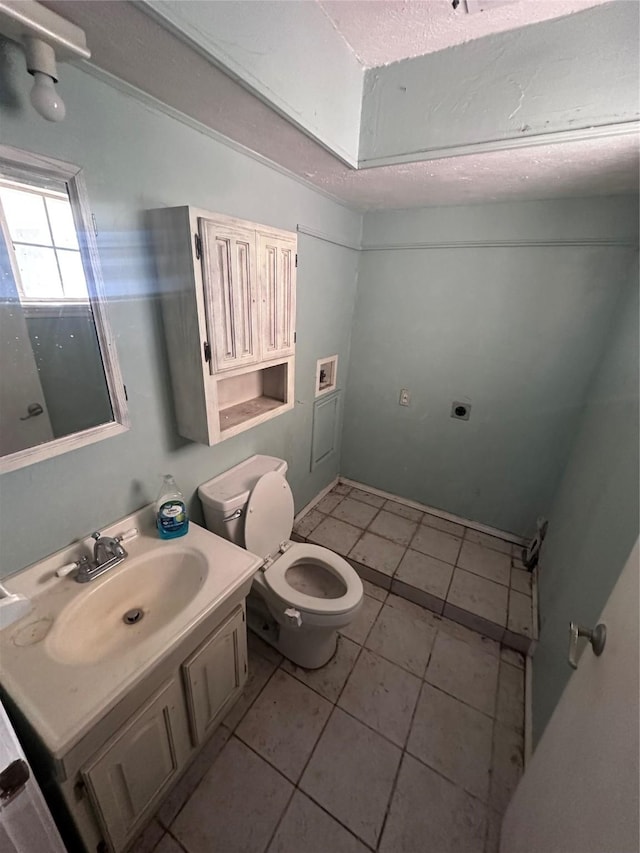 bathroom with toilet, vanity, and tile patterned floors