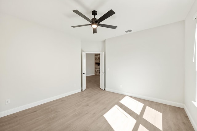 empty room with baseboards, visible vents, and light wood-style floors