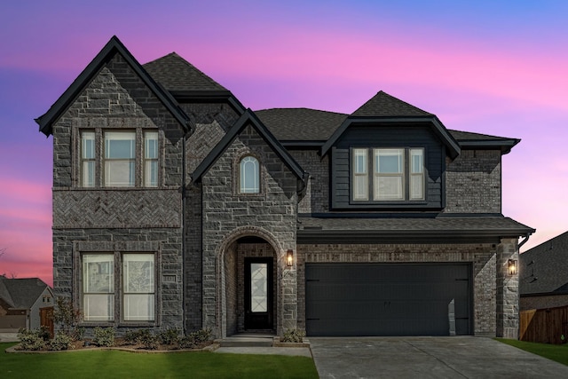 view of front of house featuring brick siding, roof with shingles, concrete driveway, a garage, and stone siding