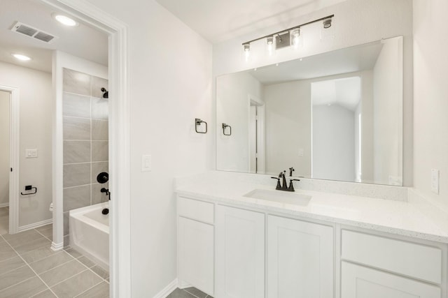 bathroom with tile patterned flooring, vanity, visible vents, and baseboards