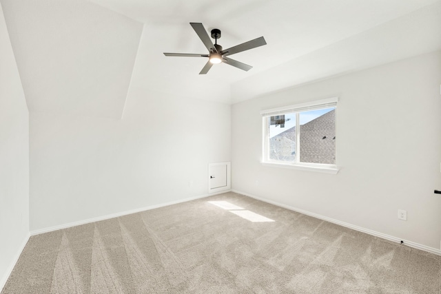 carpeted spare room with ceiling fan and baseboards