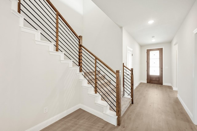 entryway with light wood-style floors, stairway, baseboards, and recessed lighting