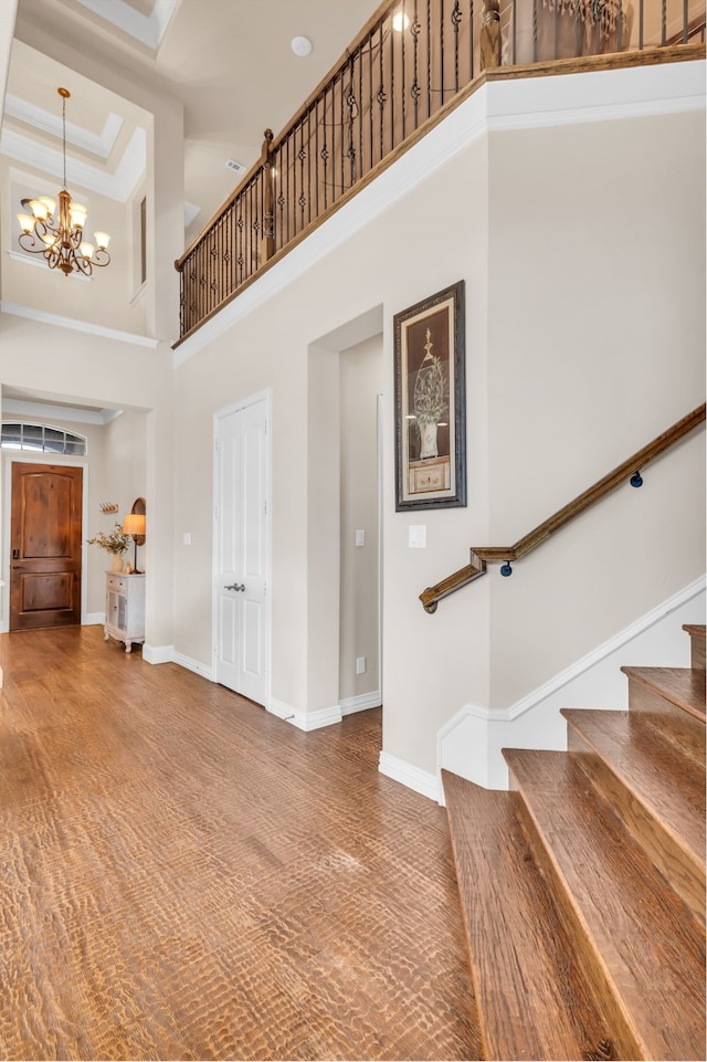 foyer entrance featuring a high ceiling, an inviting chandelier, and a tray ceiling