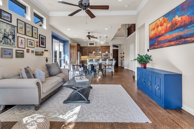 living room featuring ornamental molding, dark wood-type flooring, and a towering ceiling