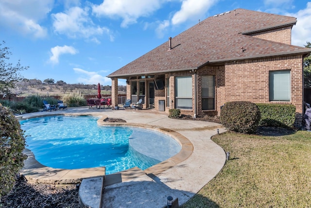 view of pool with a patio and a lawn