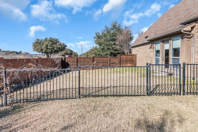 view of gate featuring a lawn