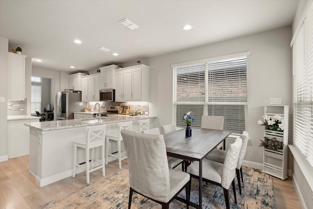 dining space featuring sink and light hardwood / wood-style floors