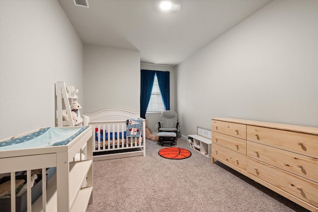 carpeted bedroom featuring a crib