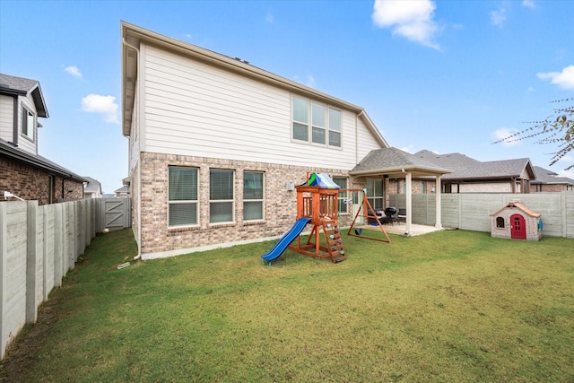 back of property featuring a lawn and a playground