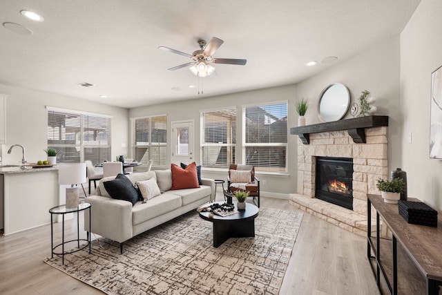 1504 Longspur Dr, Argyle, TX 76226 - living room with ceiling fan, light wood-style floors, a stone fireplace, plenty of natural light, and recessed lighting