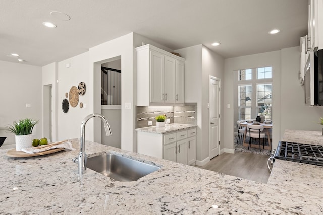 1504 Longspur Dr, Argyle, TX 76226 - kitchen with a sink, light wood-style flooring, recessed lighting, baseboards, and light stone countertops
