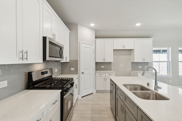 kitchen with white cabinetry, sink, and a kitchen island with sink