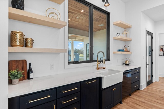 bar featuring sink and light hardwood / wood-style floors