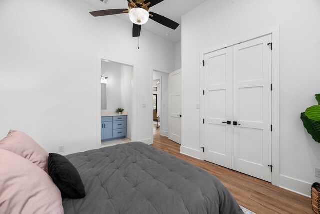 bedroom with hardwood / wood-style floors, connected bathroom, a closet, high vaulted ceiling, and ceiling fan