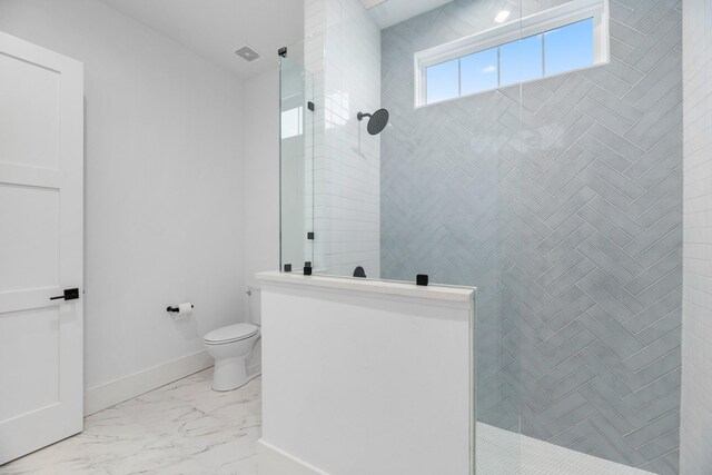 bathroom featuring toilet and tiled shower