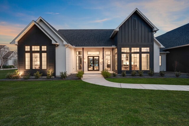 modern farmhouse style home with french doors and a lawn