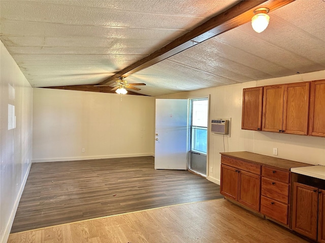 kitchen featuring vaulted ceiling with beams, dark hardwood / wood-style floors, ceiling fan, and a wall mounted AC