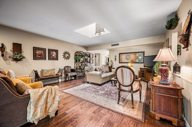 living room with wood-type flooring and a skylight