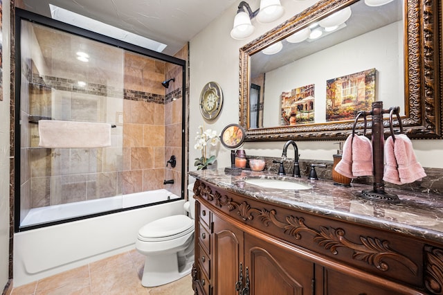 full bathroom featuring vanity, combined bath / shower with glass door, tile patterned floors, and toilet