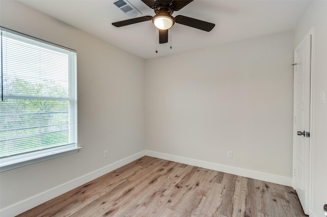 spare room featuring ceiling fan, light hardwood / wood-style floors, and a healthy amount of sunlight