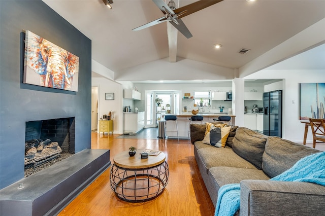 2504 Kingsridge Dr, Dallas, TX 75287 - living area featuring wood finished floors, ceiling fan, and a fireplace with raised hearth