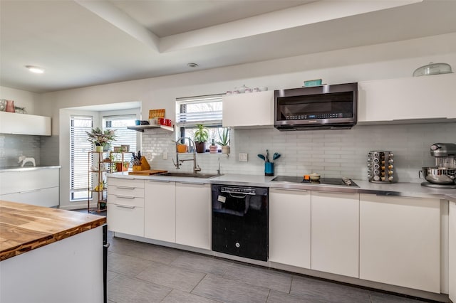 kitchen with white cabinets, wooden counters, tasteful backsplash, and black appliances