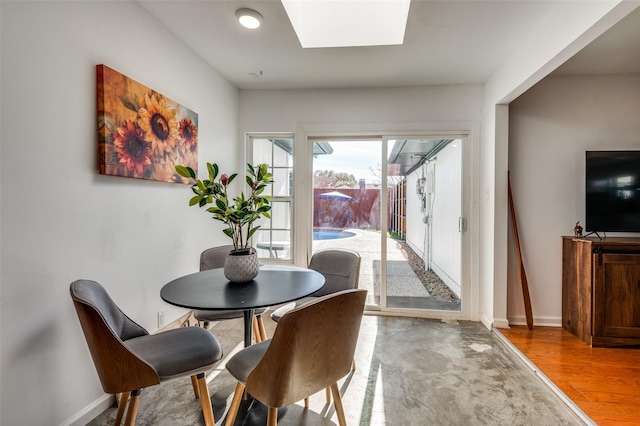 dining area featuring a skylight and light hardwood / wood-style flooring