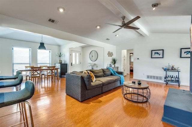 living room with lofted ceiling with beams, ceiling fan, and light wood-type flooring