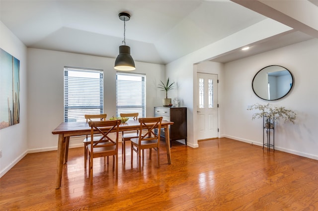 dining area with a wealth of natural light, vaulted ceiling, and hardwood / wood-style flooring