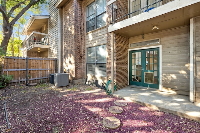 exterior space featuring central air condition unit, french doors, a balcony, and a patio