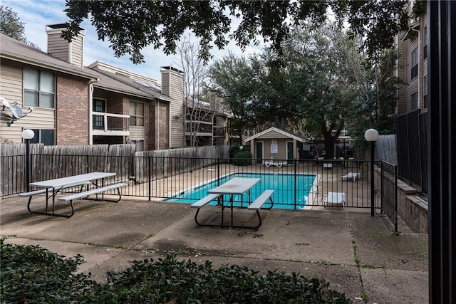 view of pool featuring a diving board and a patio area