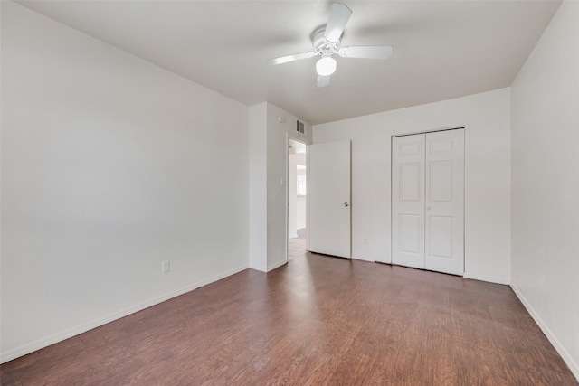 unfurnished bedroom with dark wood-type flooring, ceiling fan, and a closet