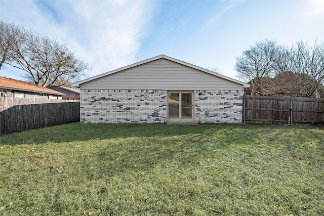 back of house featuring a lawn