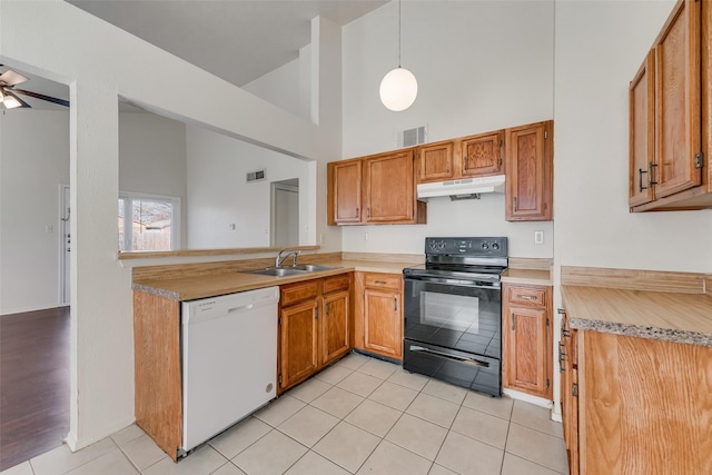 kitchen featuring white dishwasher, high vaulted ceiling, sink, decorative light fixtures, and black / electric stove