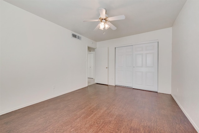 unfurnished bedroom featuring a closet, ceiling fan, and dark hardwood / wood-style floors