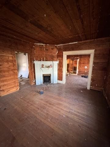 unfurnished living room featuring wood walls and wooden ceiling