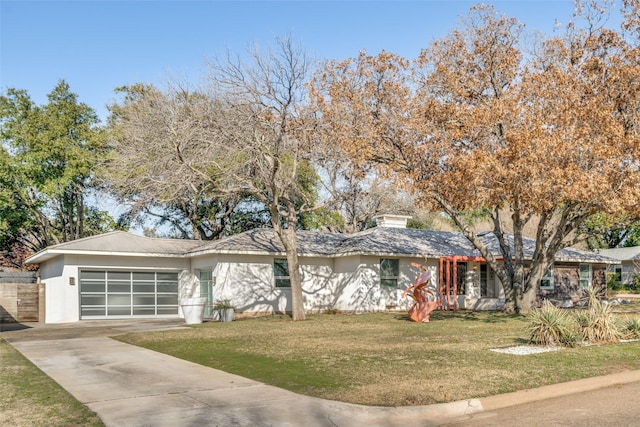 ranch-style home featuring a front lawn and a garage