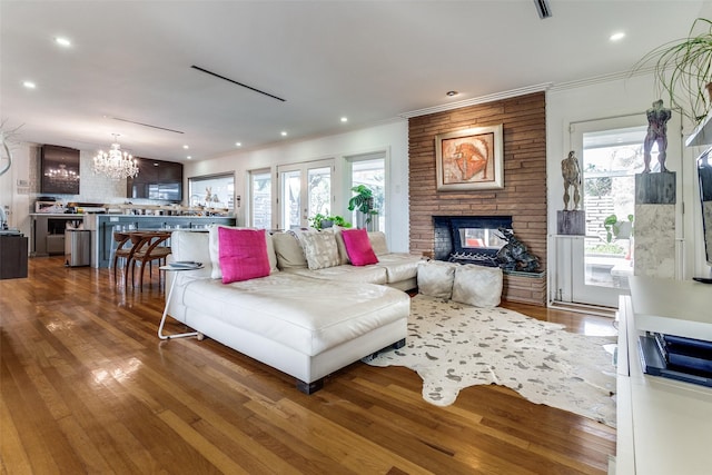 4165 Meadowdale Ln, Dallas, TX 75229 - living area featuring a multi sided fireplace, crown molding, a notable chandelier, and a healthy amount of sunlight