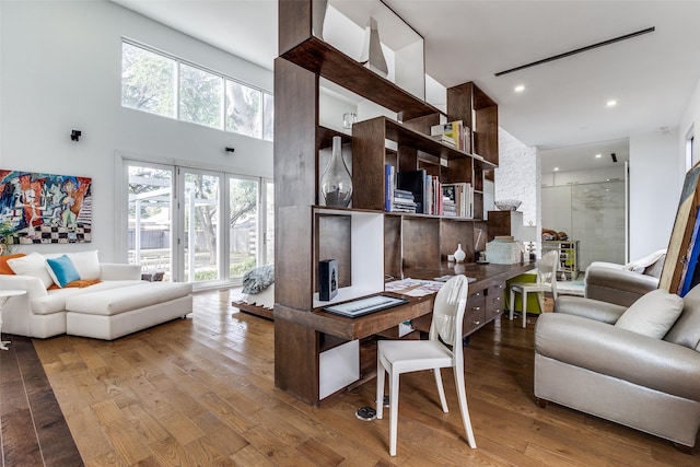 living room featuring wood-type flooring and a high ceiling