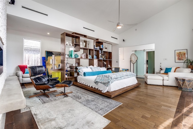 bedroom featuring hardwood / wood-style flooring, high vaulted ceiling, and ceiling fan