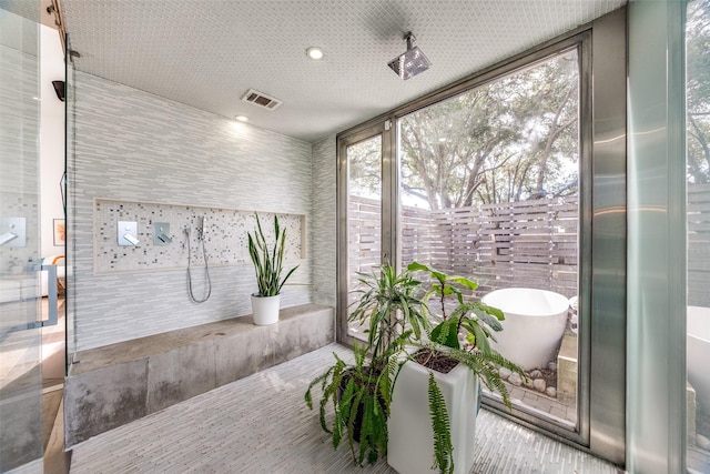 bathroom with a tub and expansive windows