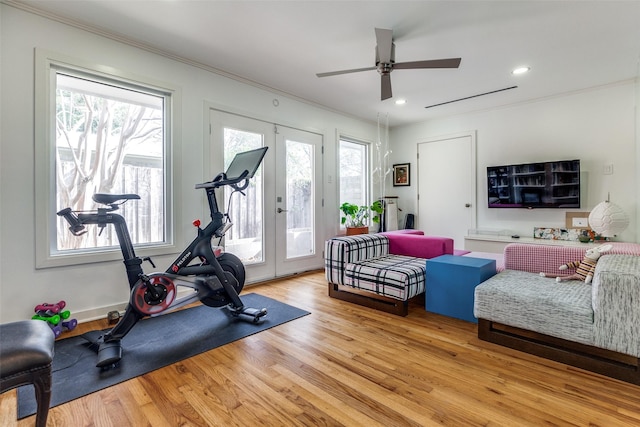 exercise area with french doors, light wood-type flooring, ceiling fan, and crown molding