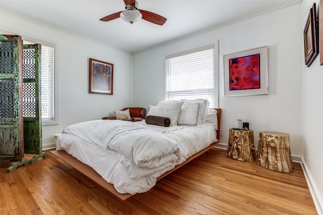 bedroom with light hardwood / wood-style flooring, ceiling fan, and crown molding