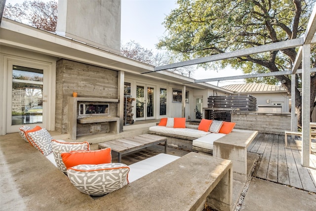 wooden deck featuring an outdoor living space with a fireplace and exterior kitchen