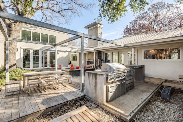 exterior space featuring a deck, grilling area, and exterior kitchen